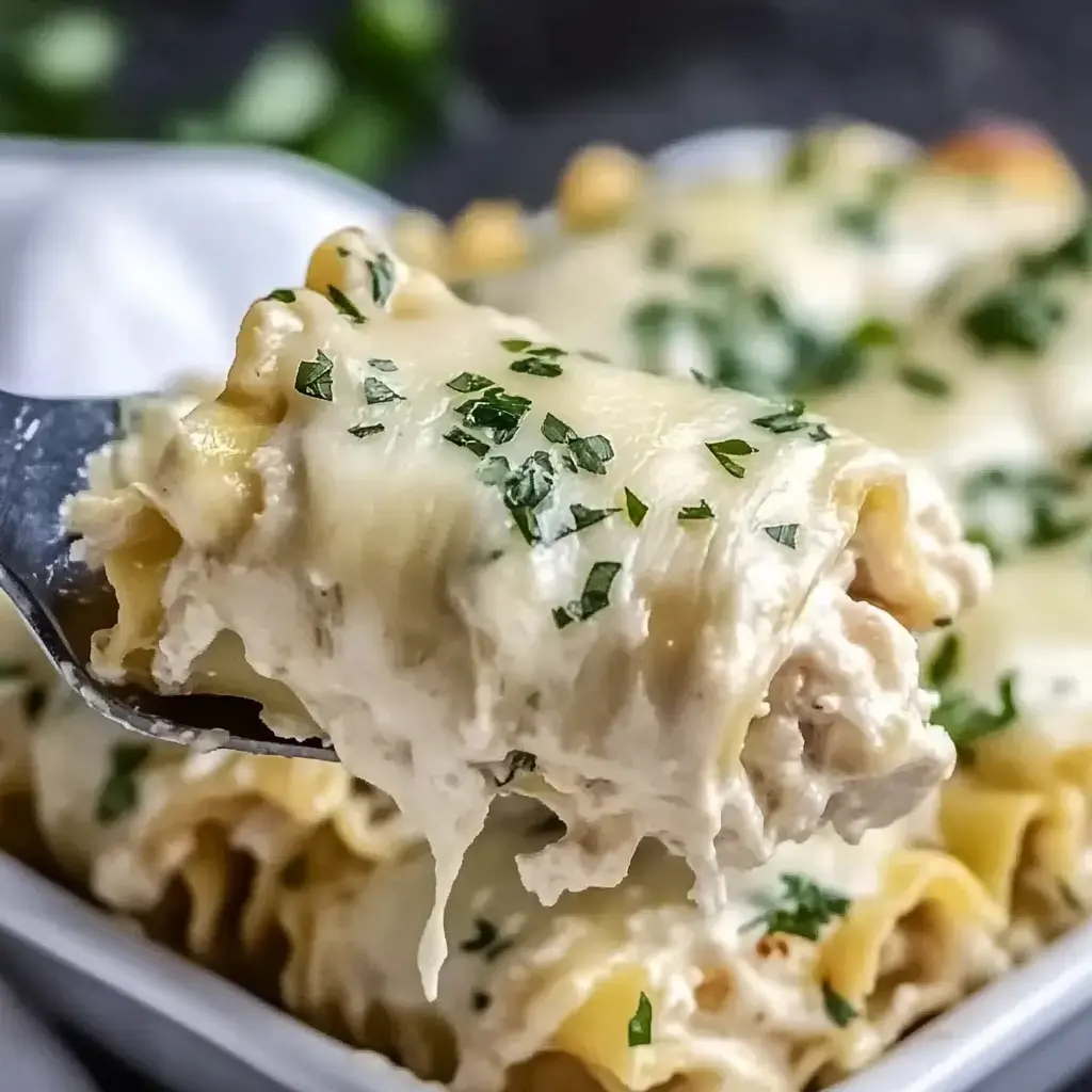 A fork lifts a cheesy chicken pasta dish beside other portions garnished with parsley.