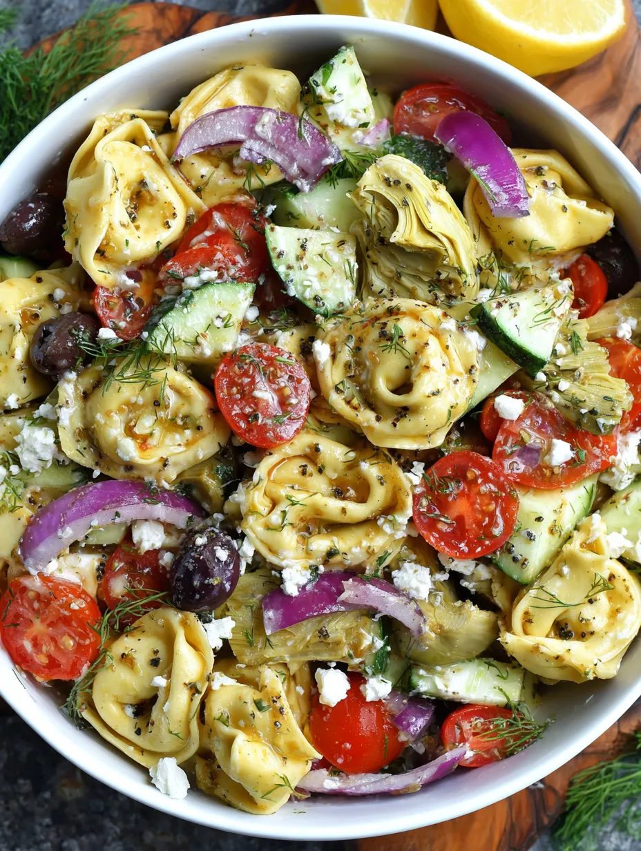 A white plate loaded up with pasta, tomatoes, zucchini, basil, olives, and shrimp.